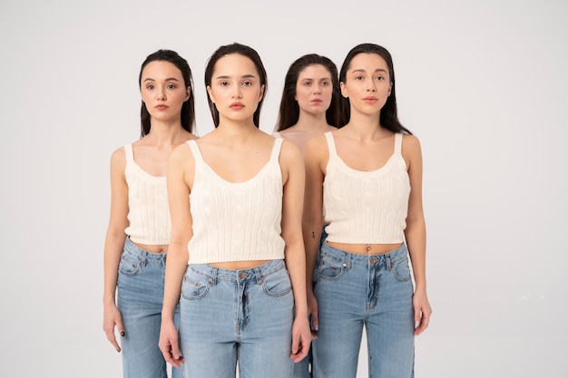 Vista frontal de mujeres en camisetas sin mangas y jeans posando en retratos minimalistas