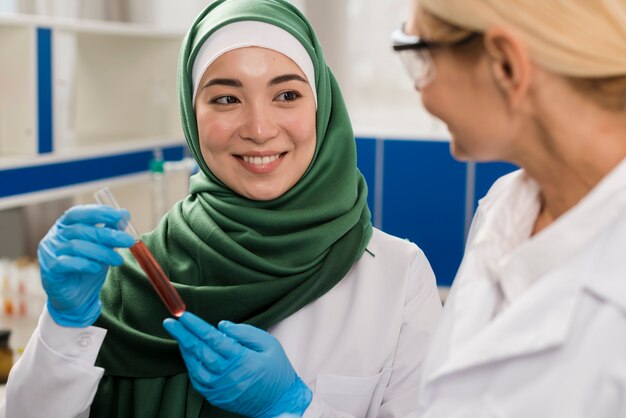 Vista frontal de mujeres científicas en el laboratorio analizando sustancia