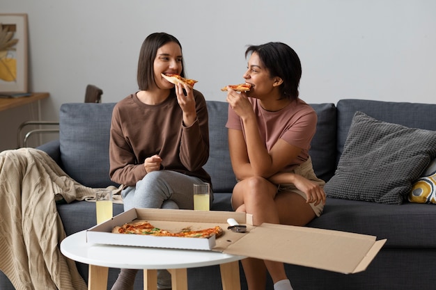 Foto gratuita vista frontal mujeres comiendo deliciosa pizza