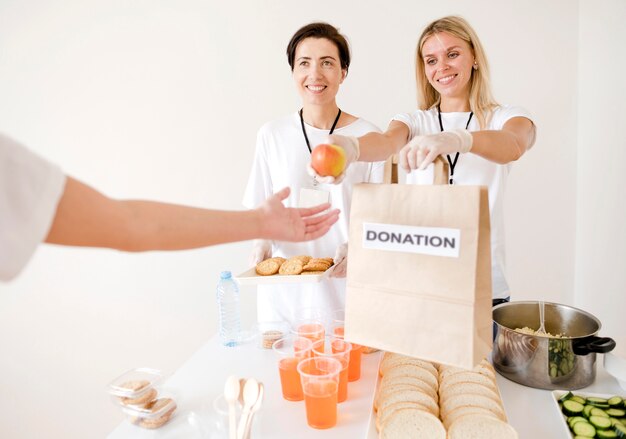 Vista frontal de mujeres donando comida