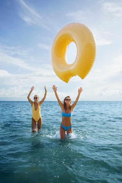 Vista frontal mujeres con donut flotante