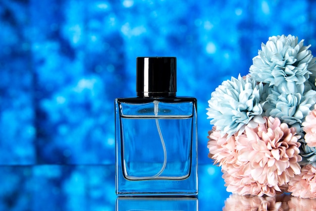 Vista frontal de las mujeres elegantes perfumes flores de colores sobre fondo azul borroso