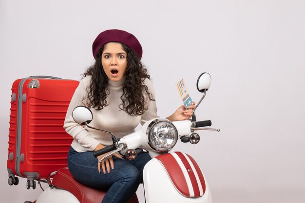 Vista frontal de las mujeres jóvenes en bicicleta sosteniendo el boleto sobre fondo blanco, color de vuelo, motocicleta, vacaciones, velocidad del vehículo de carretera