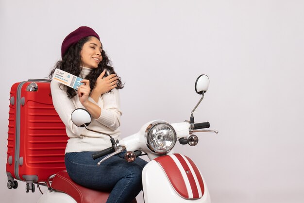 Vista frontal de las mujeres jóvenes en bicicleta sosteniendo el boleto sobre fondo blanco color de vuelo vacaciones vehículo de carretera velocidad de la ciudad