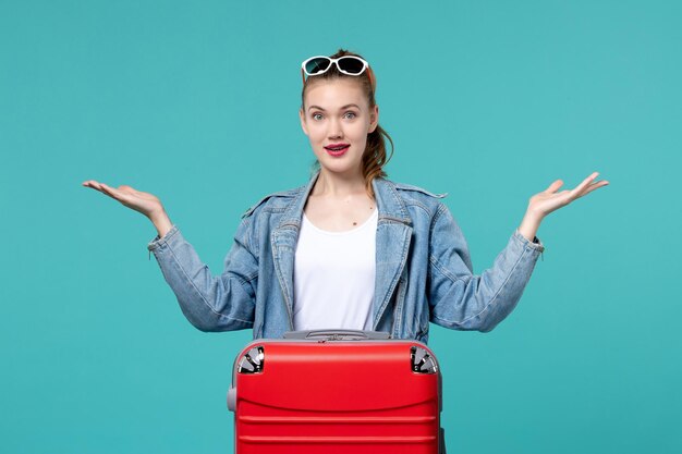 Vista frontal de las mujeres jóvenes con bolsa preparándose para las vacaciones en el espacio azul claro