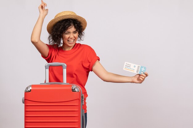 Vista frontal de las mujeres jóvenes con bolsa preparándose para el viaje sosteniendo el boleto sobre fondo blanco, color, sol, viaje, vacaciones turísticas, descanso, vuelo, avión