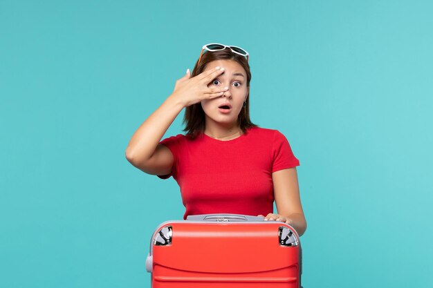 Vista frontal de las mujeres jóvenes con bolsa roja preparándose para las vacaciones en el espacio azul claro