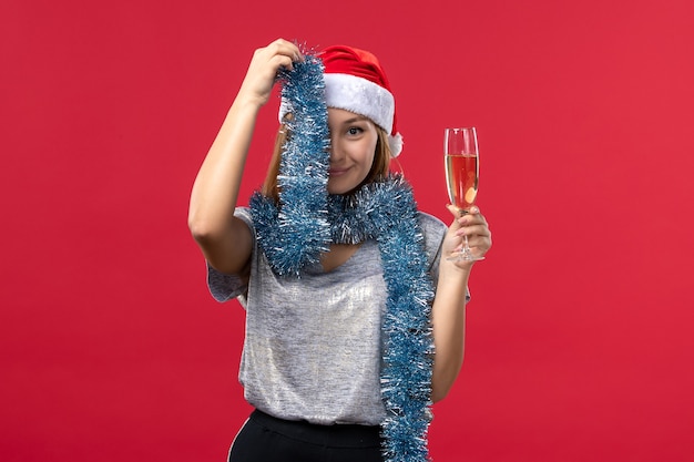 Foto gratuita vista frontal de las mujeres jóvenes celebrando el año nuevo en la pared roja color de vacaciones de navidad