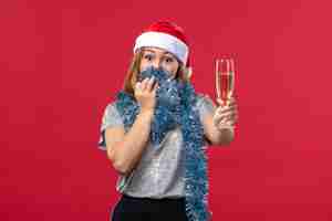 Foto gratuita vista frontal de las mujeres jóvenes celebrando el año nuevo en la pared roja color vacaciones de navidad