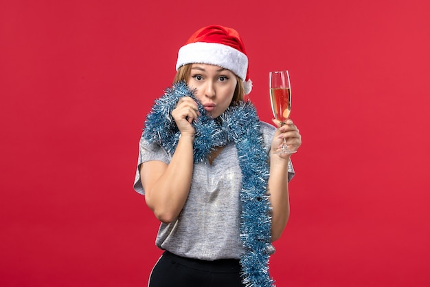 Foto gratuita vista frontal de las mujeres jóvenes celebrando el año nuevo en la pared roja color de vacaciones de navidad