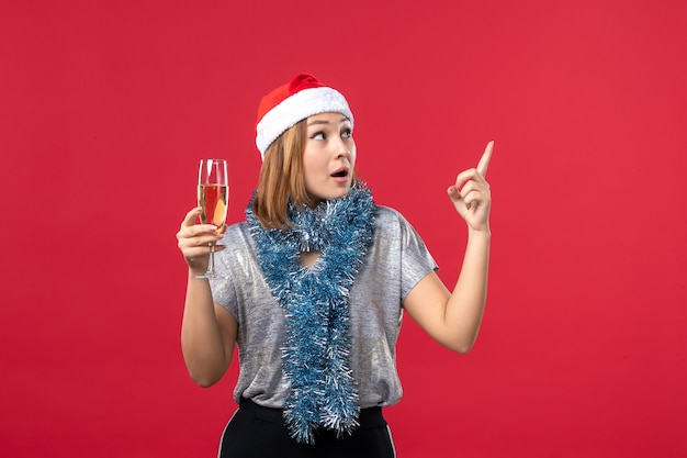 Vista frontal de las mujeres jóvenes celebrando el año nuevo en la pared roja color de vacaciones Navidad