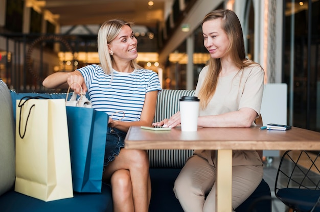 Vista frontal de las mujeres jóvenes disfrutando de un café