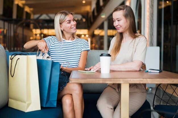 Vista frontal de las mujeres jóvenes disfrutando de un café