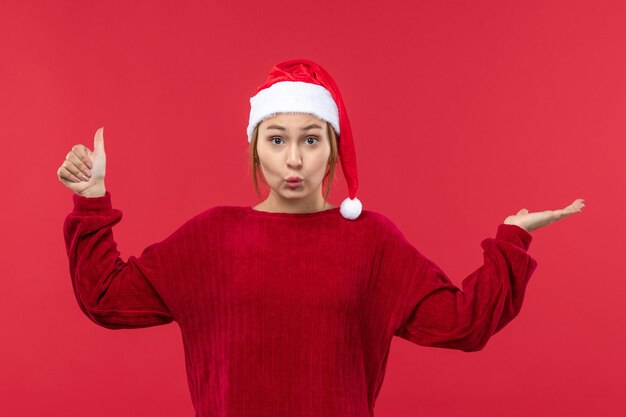 Vista frontal de las mujeres jóvenes con gorra roja, humor navideño, vacaciones navideñas rojas