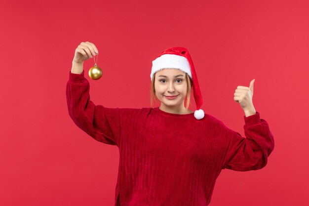 Vista frontal de las mujeres jóvenes con juguetes de bolas de Navidad, vacaciones de Navidad rojo