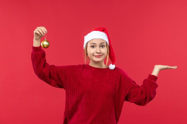 Vista frontal de las mujeres jóvenes con juguetes de bolas de navidad, vacaciones de navidad rojo