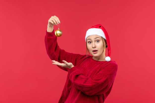 Vista frontal de las mujeres jóvenes con juguetes de navidad, rojo de vacaciones de navidad