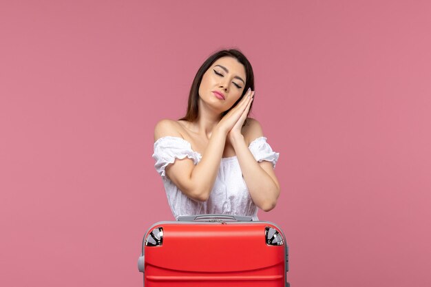 Vista frontal de las mujeres jóvenes preparándose para las vacaciones y sentirse cansado sobre fondo rosa en el extranjero viaje por mar viaje viaje viaje