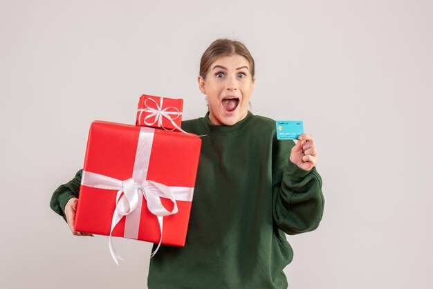 Vista frontal de las mujeres jóvenes con regalos de Navidad y tarjeta bancaria