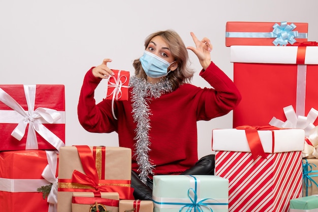 Vista frontal de las mujeres jóvenes sentados alrededor de diferentes regalos