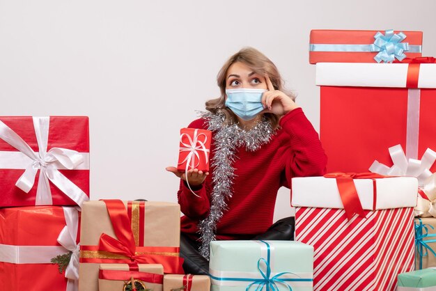 Vista frontal de las mujeres jóvenes sentados alrededor de diferentes regalos