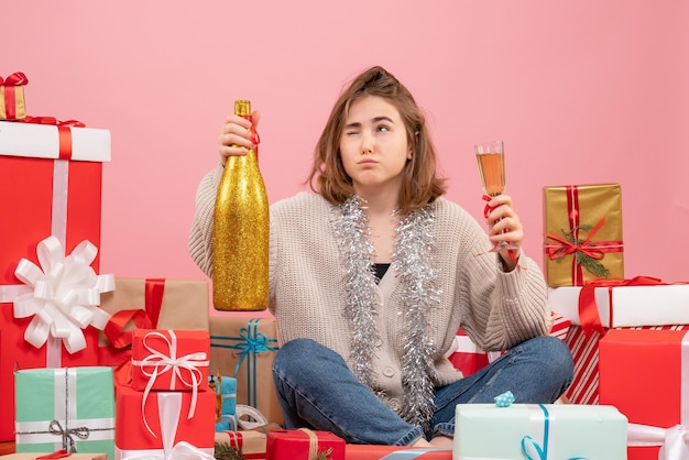 Vista frontal de las mujeres jóvenes sentados alrededor de regalos