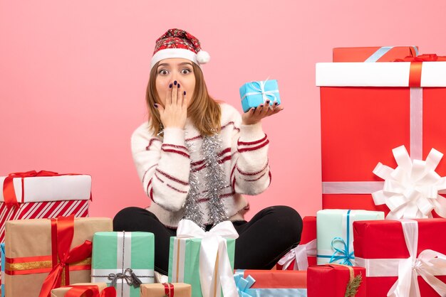 Vista frontal de las mujeres jóvenes sentados alrededor de los regalos de Navidad