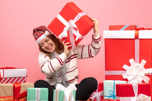 Vista frontal de las mujeres jóvenes sentados alrededor de los regalos de Navidad