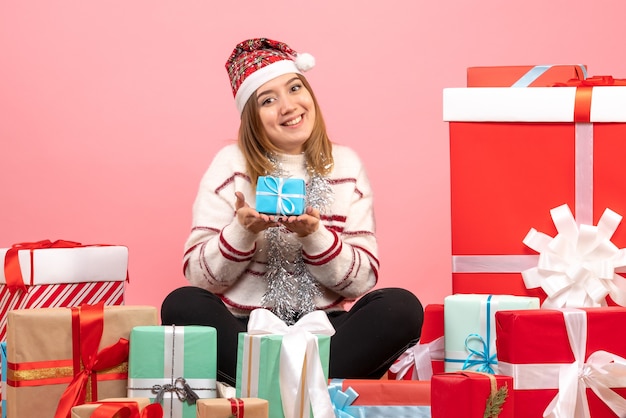 Vista frontal de las mujeres jóvenes sentados alrededor de los regalos de Navidad