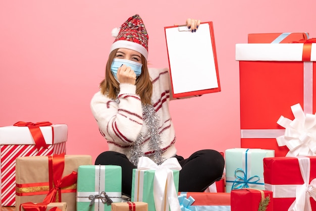 Foto gratuita vista frontal de las mujeres jóvenes sentados alrededor de regalos con nota de archivo