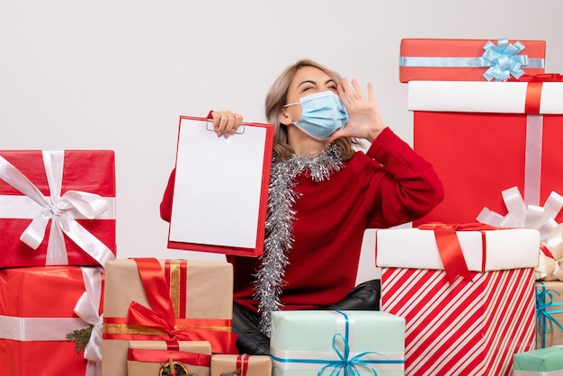 Foto gratuita vista frontal de las mujeres jóvenes sentados alrededor de regalos con nota