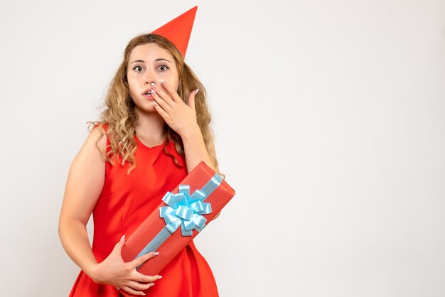 Vista frontal de las mujeres jóvenes en vestido rojo celebrando la Navidad con el presente