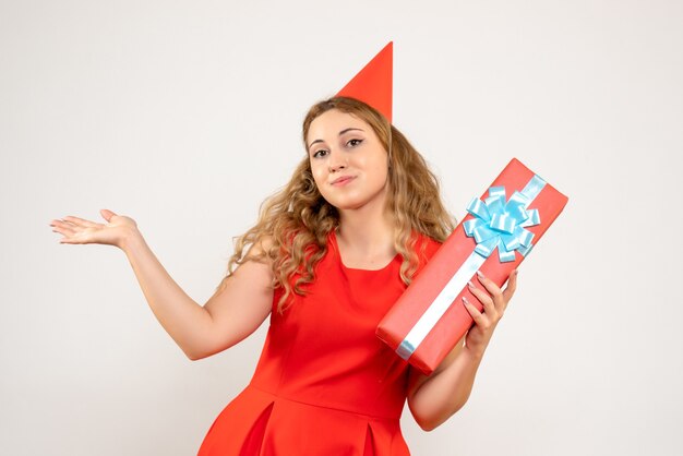 Vista frontal de las mujeres jóvenes en vestido rojo celebrando la Navidad con el presente