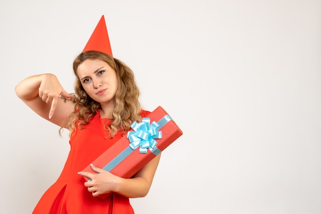 Vista frontal de las mujeres jóvenes en vestido rojo celebrando la Navidad con el presente