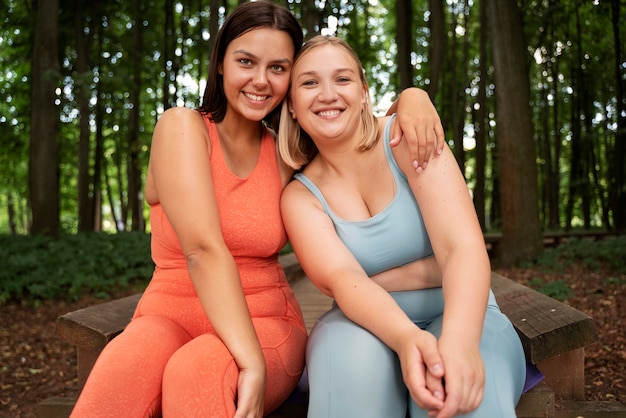 Vista frontal de las mujeres sonrientes posando juntos