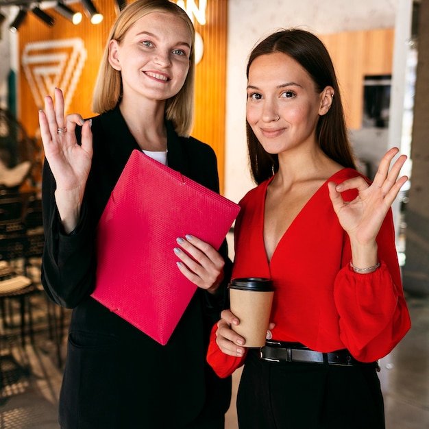 Foto gratuita vista frontal de las mujeres en el trabajo usando lenguaje de señas