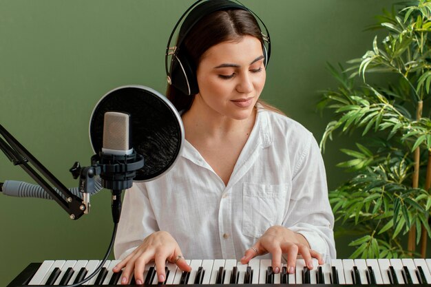 Vista frontal del músico femenino tocando el teclado del piano