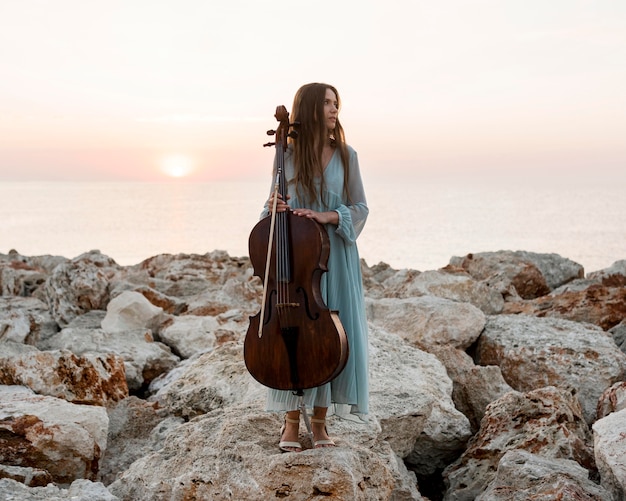Vista frontal del músico femenino con violonchelo