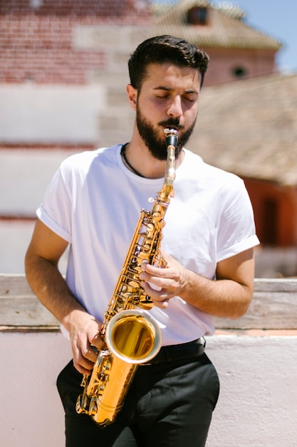 Foto gratuita vista frontal músico de tiro medio tocando el saxofón