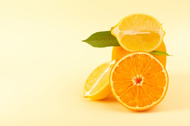 Una vista frontal de naranja entera y pieza en rodajas junto con limón en rodajas maduras frescas jugosas suaves aisladas sobre el fondo crema de cítricos naranja