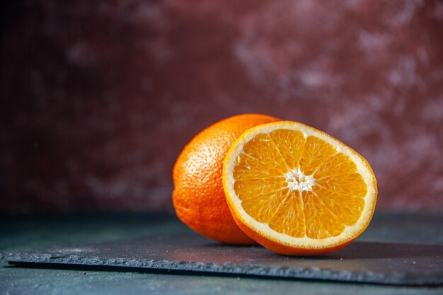 Vista frontal de naranja fresca en rodajas sobre fondo oscuro jugo de fruta suave madura color cítrico sabor cítrico