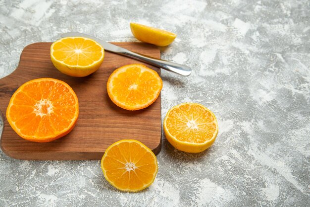 Vista frontal de las naranjas en rodajas frescas cítricos suaves sobre fondo blanco frutas maduras tropicales frescas exóticas