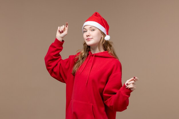 Vista frontal Navidad niña bailando sobre fondo marrón mujer vacaciones Navidad