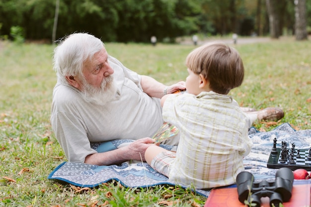 Foto gratuita vista frontal nieto y abuelo en picnic