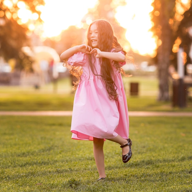 Vista frontal niña asiática con cabello largo caminando en el parque