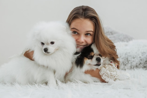 Vista frontal de niña y cachorros blancos lindos