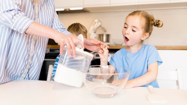 Vista frontal de niña cocinando en casa