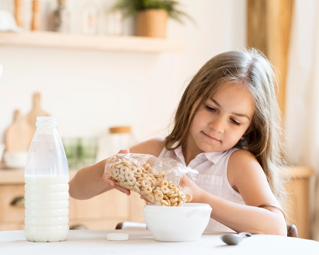 Vista frontal de la niña comiendo cereales