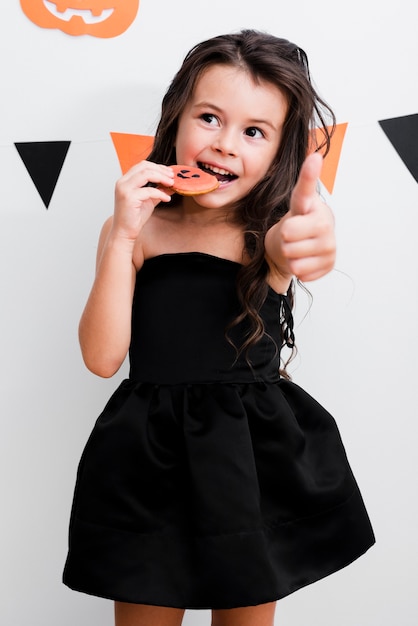 Vista frontal niña comiendo una galleta