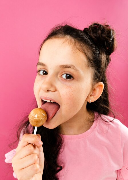 Vista frontal niña comiendo paleta